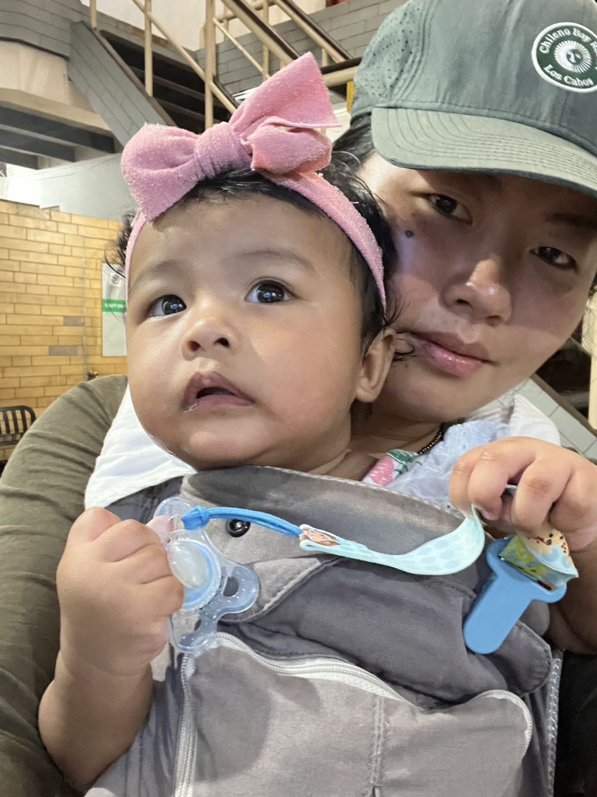 妈妈用背带把阿雅背在胸前，一起出门