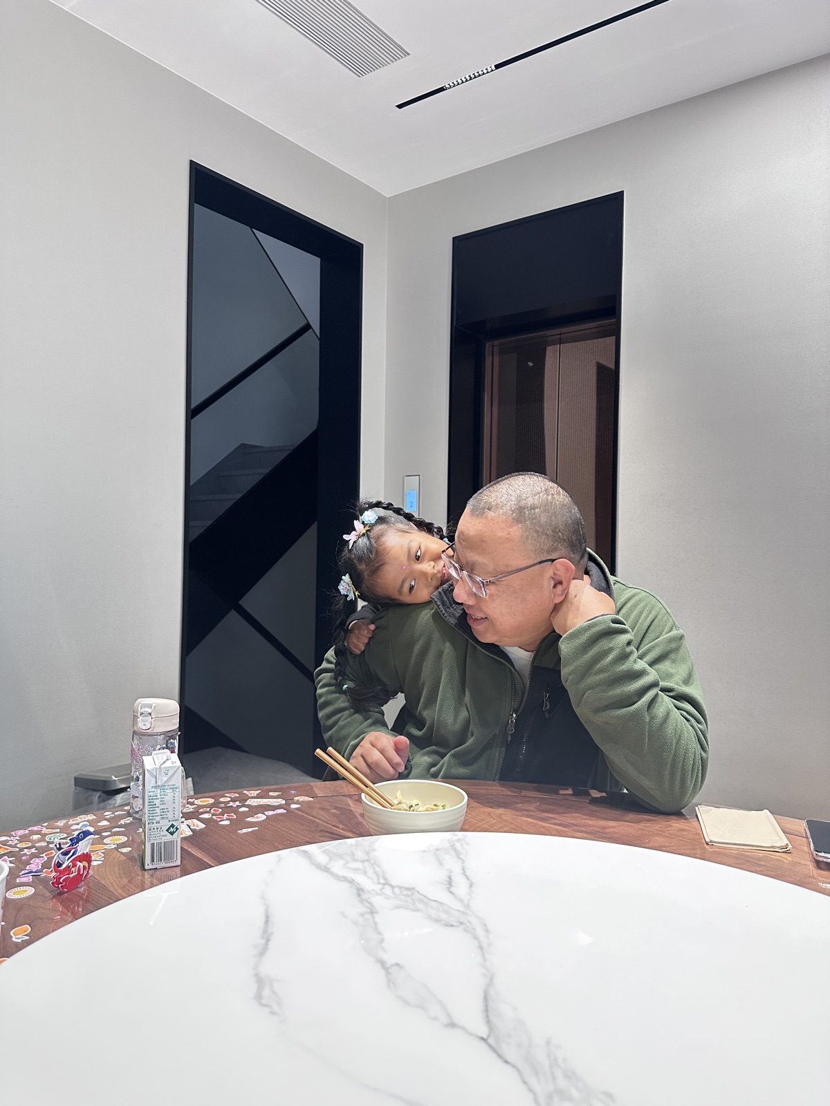 餐桌旁，外公抱着小阿雅一起看窗外