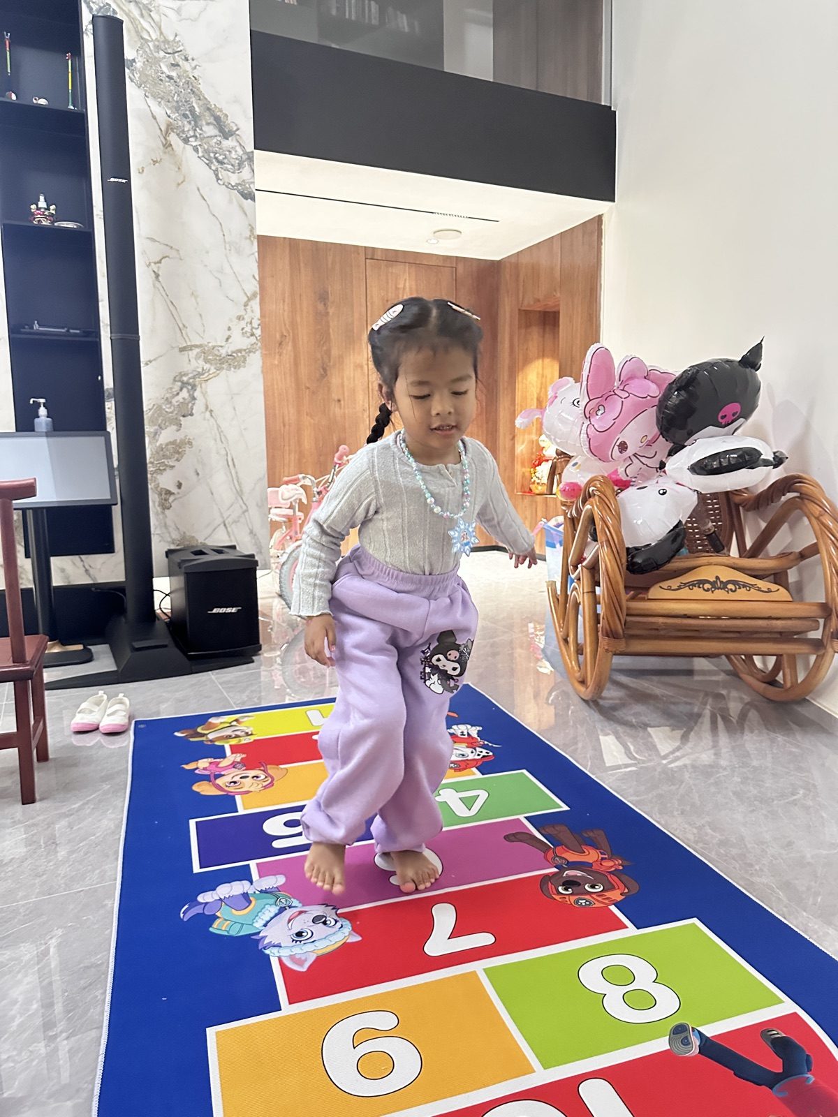 彩色地垫上跳格子，家里的小狗在旁边凑热闹